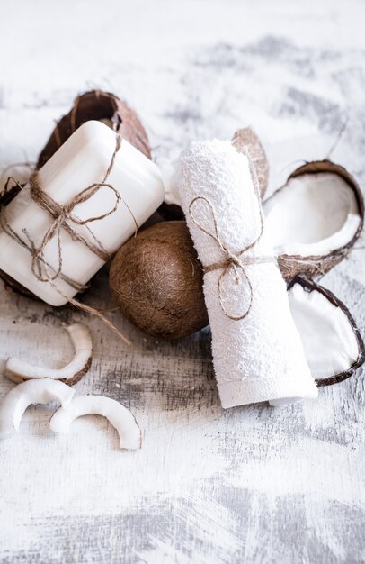 Bodegón de spa de cosmética orgánica con cocos sobre un fondo de madera clara, concepto de cuidado corporal