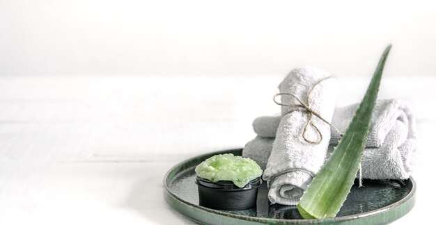 Bodegón de spa con cuidado de la piel orgánico, hojas frescas de aloe y toallas.