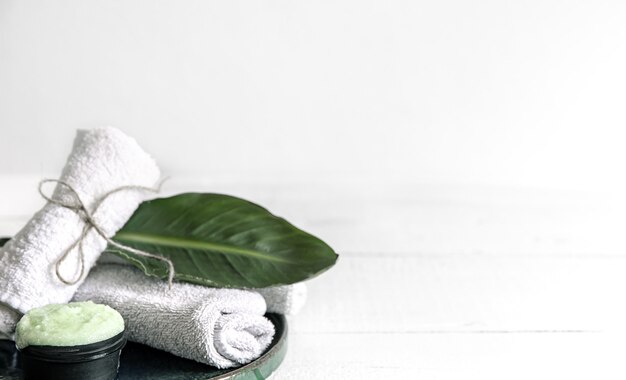 Bodegón de spa con cuidado de la piel orgánico, hojas naturales y toallas.