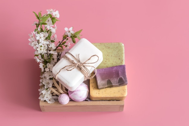 Bodegón de spa en pared rosa con flores de primavera