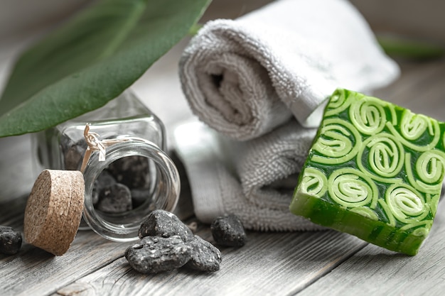 Bodegón de spa con piedras en un frasco, jabón artesanal y toallas. Concepto de salud y belleza.