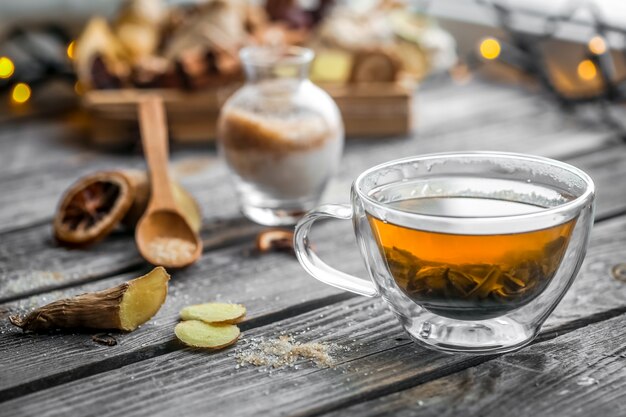 Bodegón con transparente taza de té sobre fondo de madera