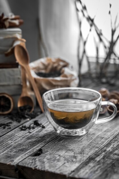 Bodegón con transparente taza de té sobre fondo de madera