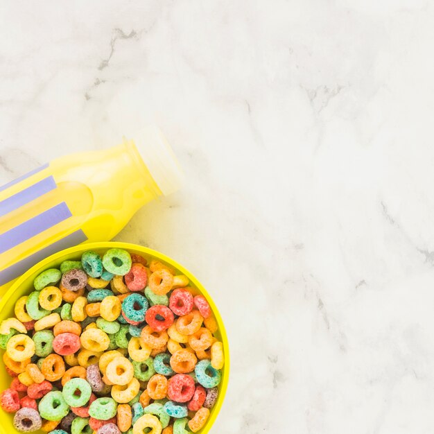 Bol con cereales y botella de leche amarilla.