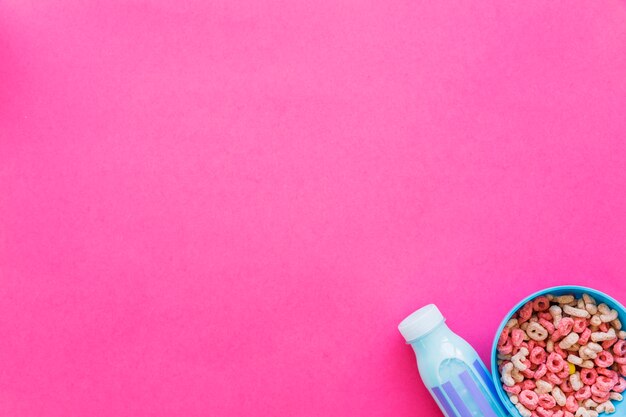 Bol con cereales y botella de leche azul.