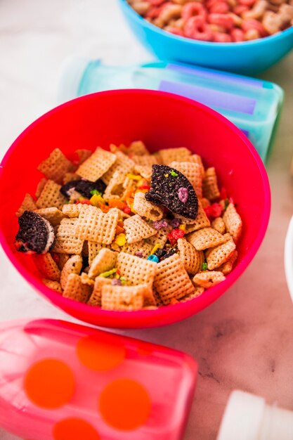 Bol rojo de cereal con botellas de leche.