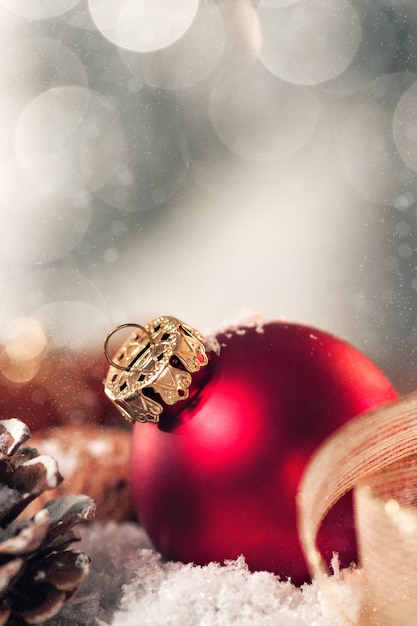 Bola de Navidad con decoración con velas, conos de abeto, nueces, nieve y cinta, primer plano, entonado