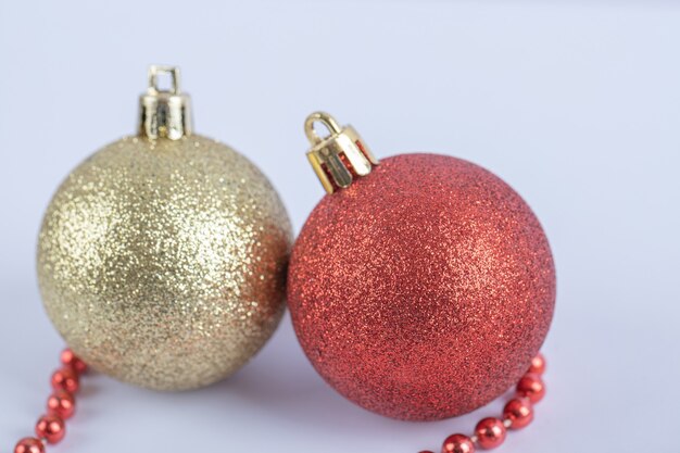 Bolas de árbol de Navidad con cadena de perlas rojas sobre el blanco