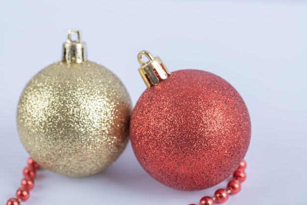 Bolas de árbol de Navidad con cadena de perlas rojas sobre el blanco
