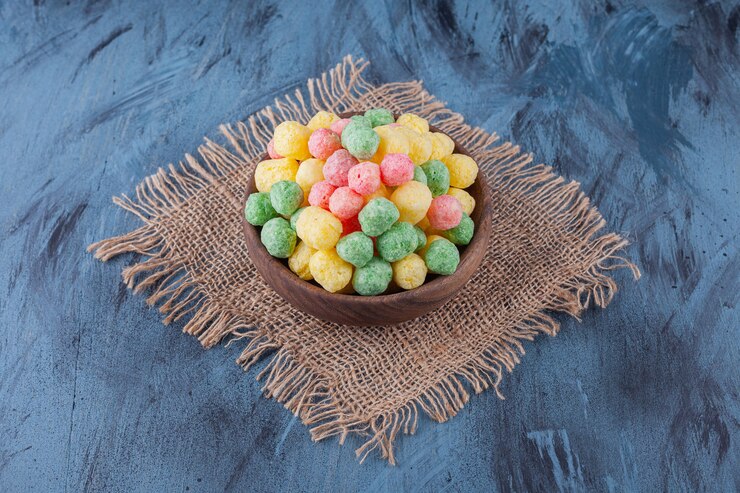 Foto gratuito bolas de cereales de colores colocadas en un cuenco de madera.