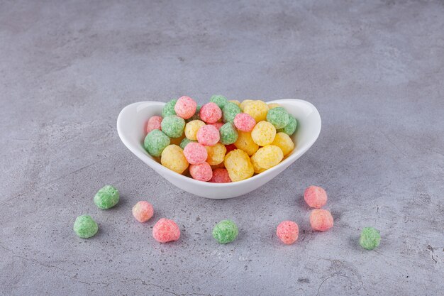 Bolas de cereales de colores colocadas en una pizarra blanca.