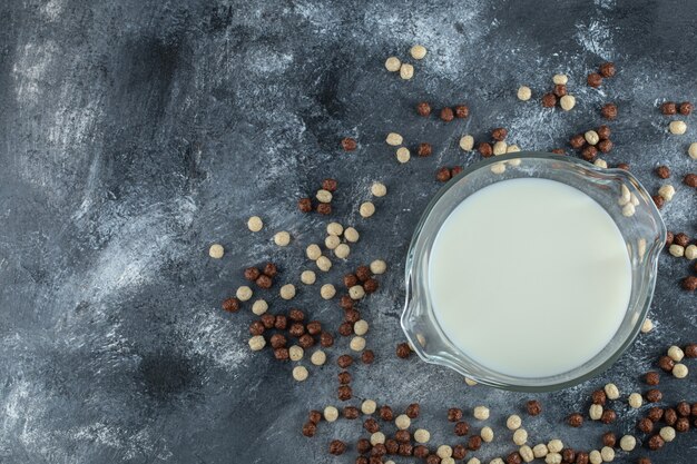 Bolas de cereales y leche ecológica sobre mármol.