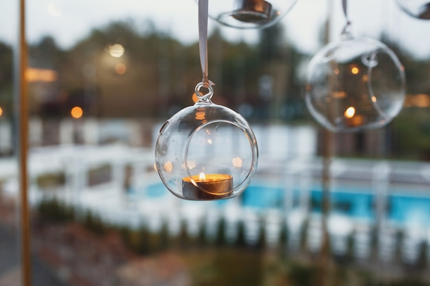 Bolas de cristal con velas colgadas antes de la ventana