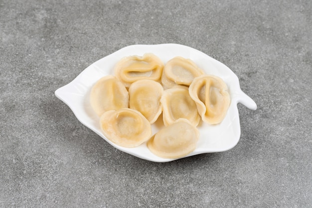 Bolas de masa hervida rellenas de carne en la placa blanca.