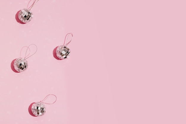 Bolas de Navidad de plata sobre fondo rosa con espacio de copia