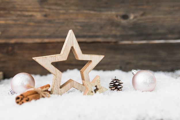 Bolas navideñas cerca de artículos de madera sobre nieve.