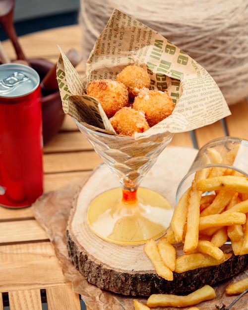 Foto gratuita bolas de queso con papas fritas en la mesa