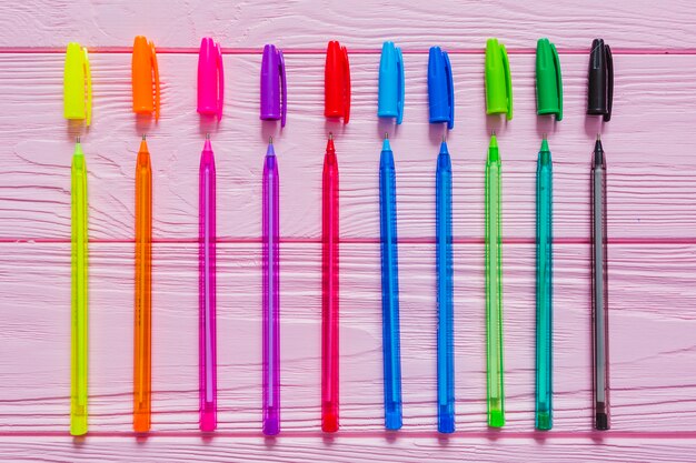 Bolígrafos de colores sobre mesa rosa