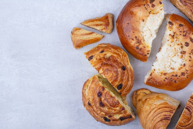 Foto gratuita bollería medio cortada con queso y pasas.