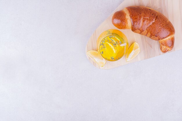 Bollo de croissant con un vaso de limonada