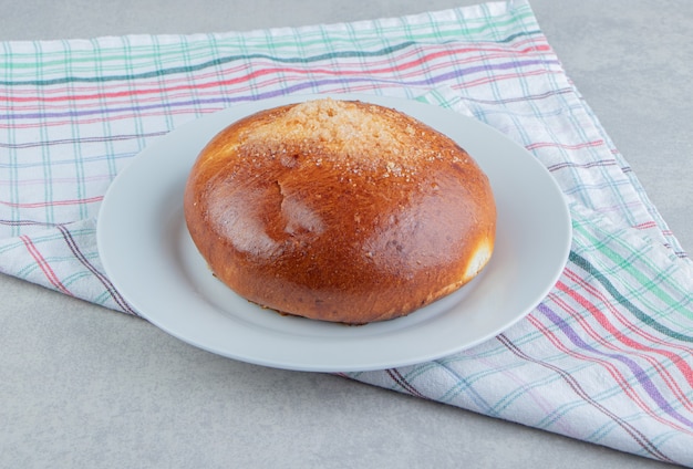 Foto gratuita bollo dulce con un paño en un plato blanco.