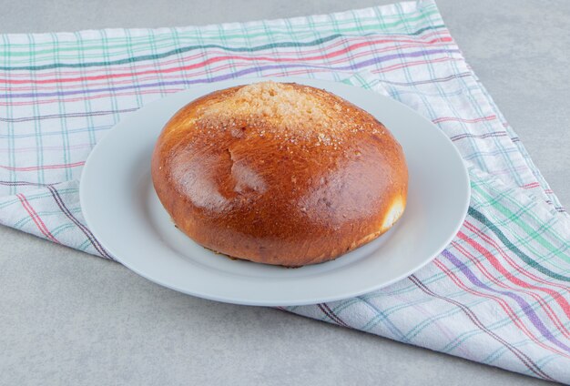 Bollo dulce con un paño en un plato blanco.