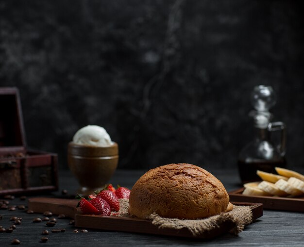 Un bollo de pan casero con fresas y bola de helado.