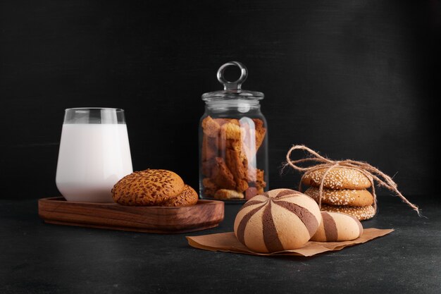 Bollos de galleta de cacao en un papel con leche y frutos secos.