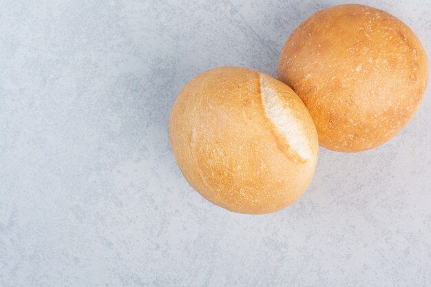 Bollos de hamburguesa redondos sobre superficie de piedra