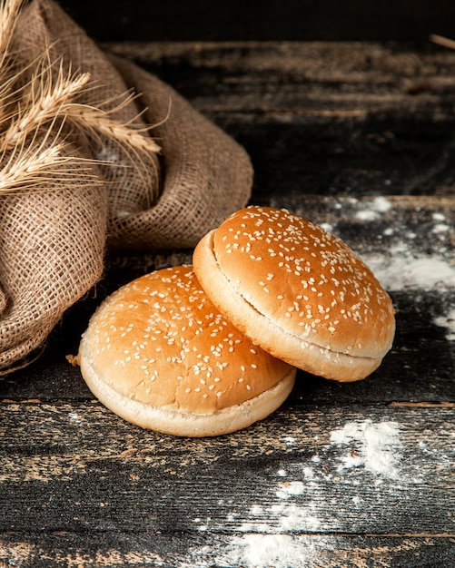 Foto gratuita bollos de hamburguesa con semillas de sésamo trigo y harina en la mesa