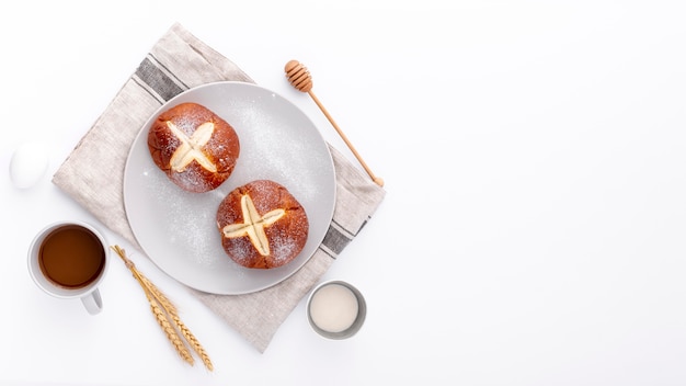 Bollos horneados sobre tela con taza de café y espacio de copia