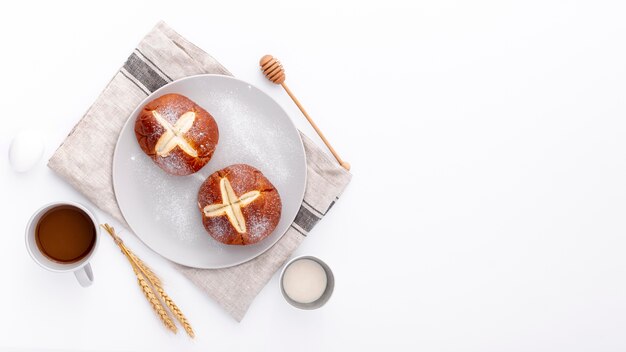 Bollos horneados sobre tela con taza de café y espacio de copia