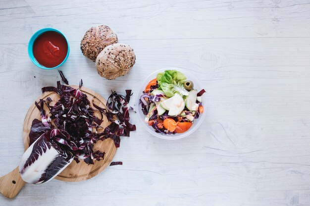 Bollos y salsa cerca de repollo y ensalada