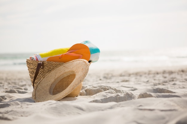 Bolsa con accesorios de playa sobre la arena mantuvo