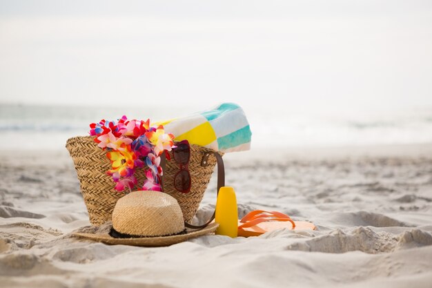Bolsa con accesorios de playa sobre la arena mantuvo