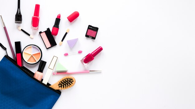 Bolsa de belleza con diferentes cosméticos en la mesa.