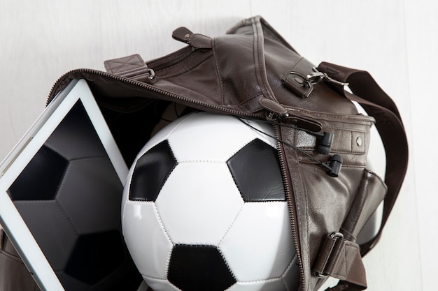 Foto gratuita bolsa de cuero repleta de fútbol y tablet