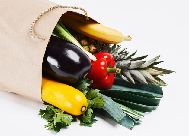 Bolsa de papel llena de verduras de temporada