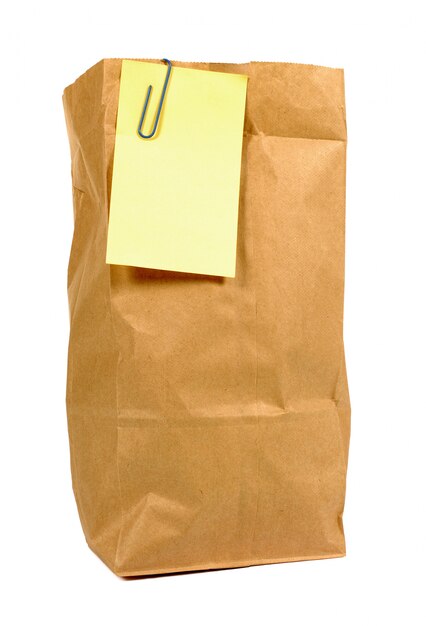 Bolsa de papel marrón con un post it amarillo