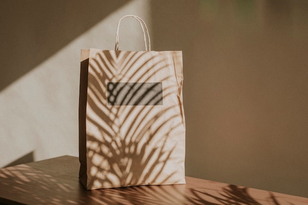 Bolsa de papel natural con sombra de hojas de palmera