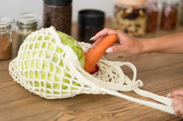 Bolsa reciclable con verduras en mesa de madera