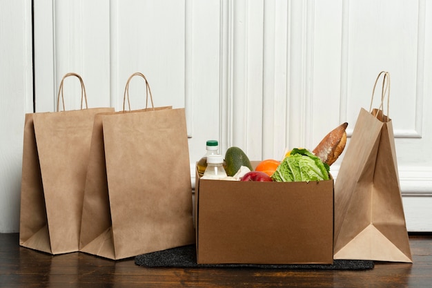 Bolsas y caja de verduras sobre tapete