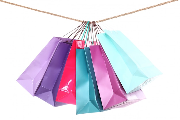 Bolsas coloridas de compras colgando de una cuerda