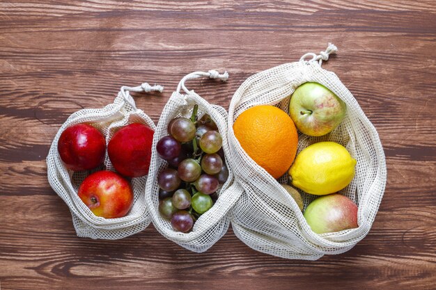 Bolsas de la compra ecológicas sencillas de algodón beige para comprar frutas y verduras con frutas de verano.