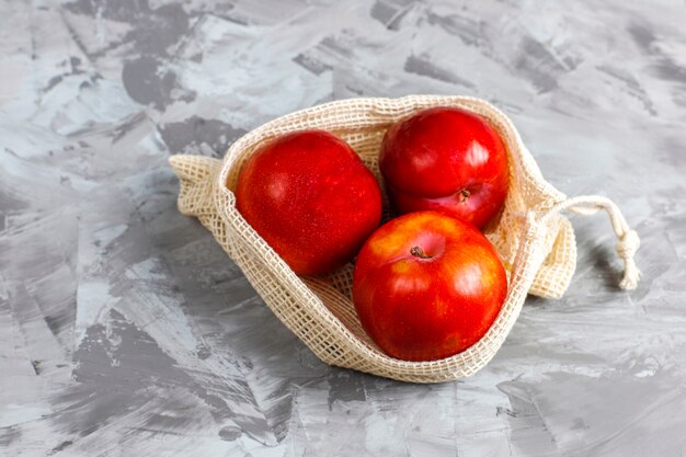 Bolsas de la compra ecológicas sencillas de algodón beige para comprar frutas y verduras con frutas de verano.