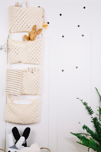 Bolsas con cosas de bebé en la pared de la guardería