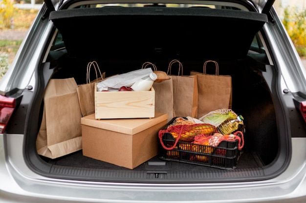 Bolsas de papel y cajas en el maletero del automóvil.