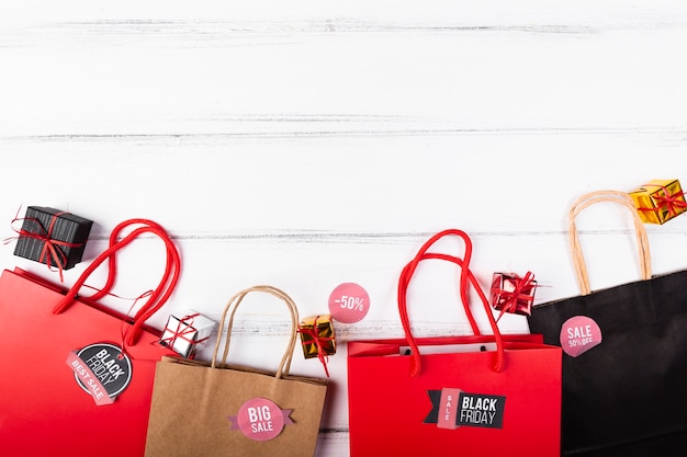 Foto gratuita bolsas de regalo de viernes negro sobre fondo de madera