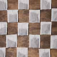 Foto gratuita bolsita de té a cuadros sobre fondo de madera con textura