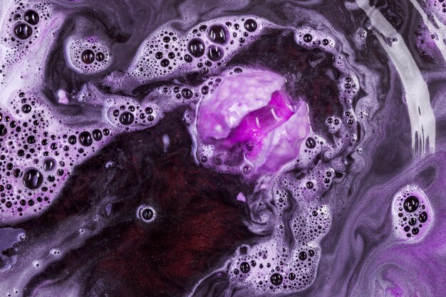 Bomba de baño púrpura efervescente en agua